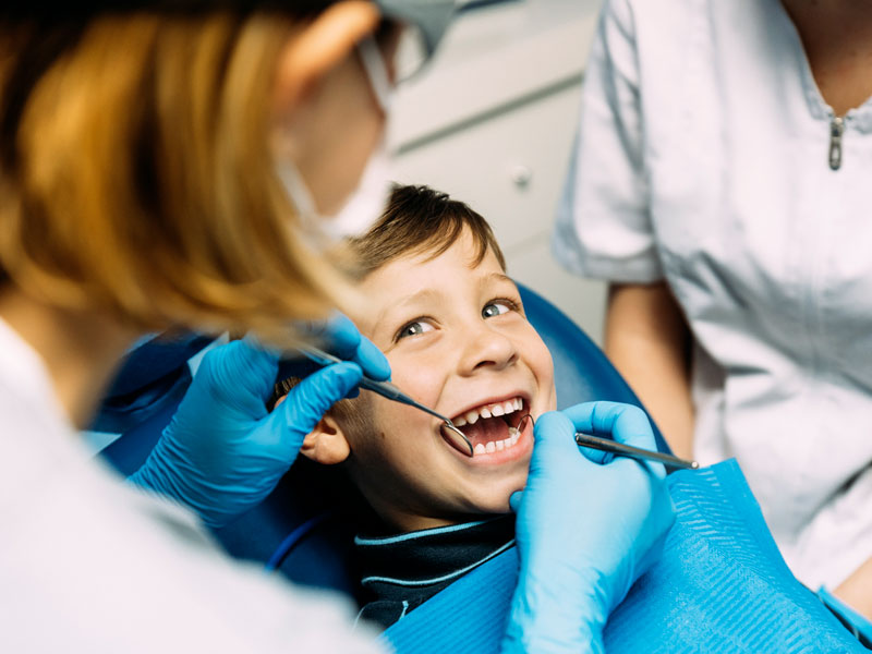 Dentist examining young boy's mouth